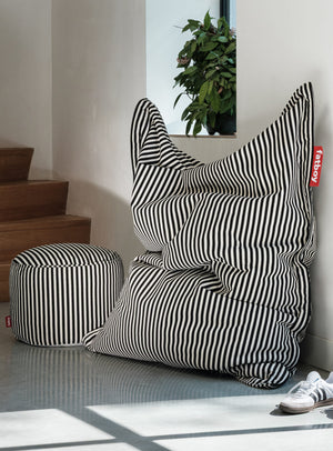 Black and white striped bean bag chair with matching Point Terry ottoman in a modern interior setting.
