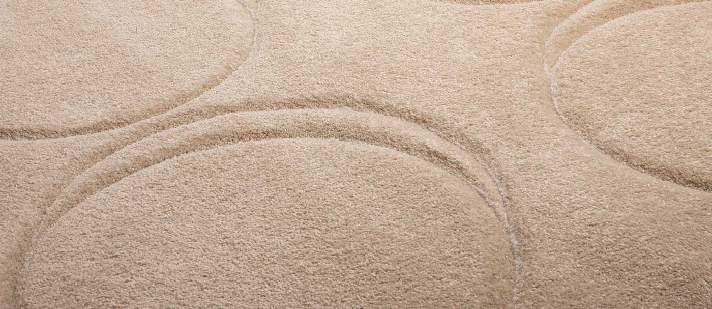 The Dot Carpet: A sophisticated, comfort-focused Canadian rug featuring a neutral color scheme, varied pile heights, and whimsical circular designs.